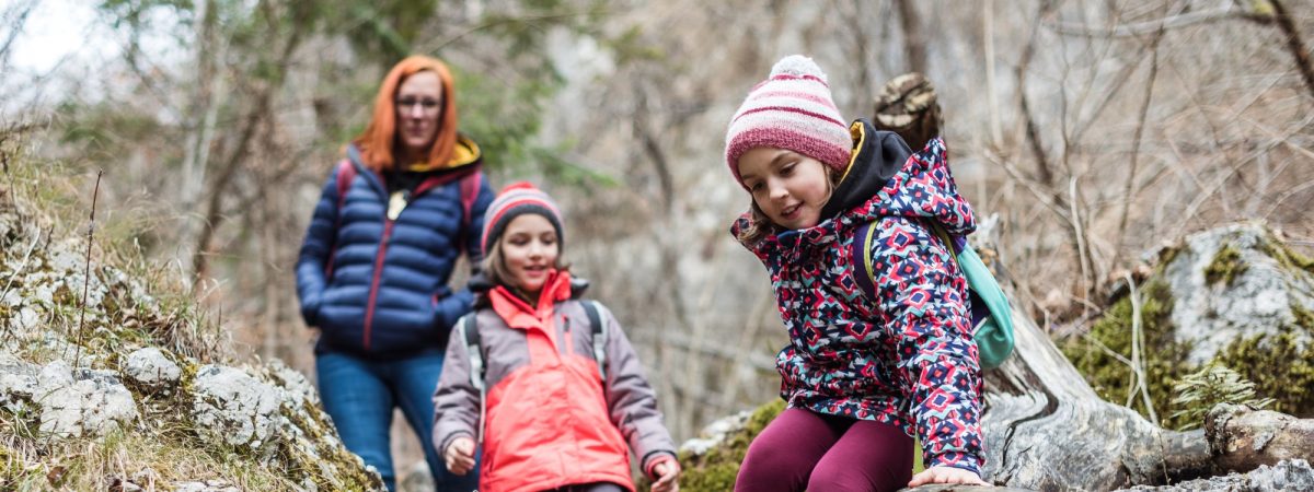 A family of a mother and two children enjoy hiking during as one of their half term experiences.