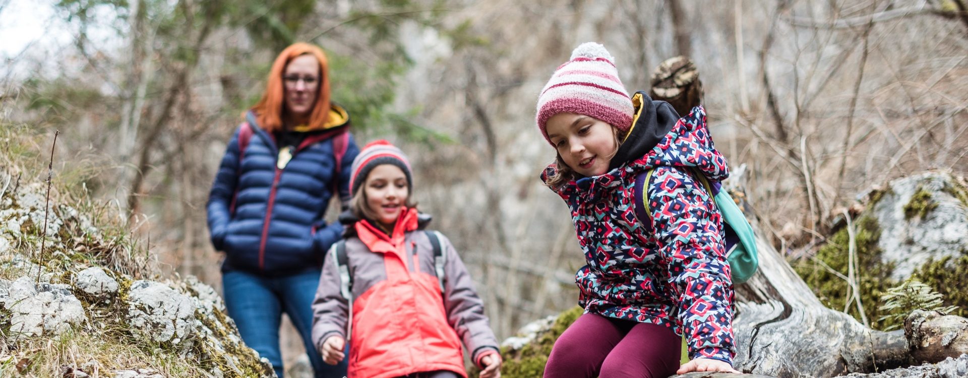 A family of a mother and two children enjoy hiking during as one of their half term experiences.